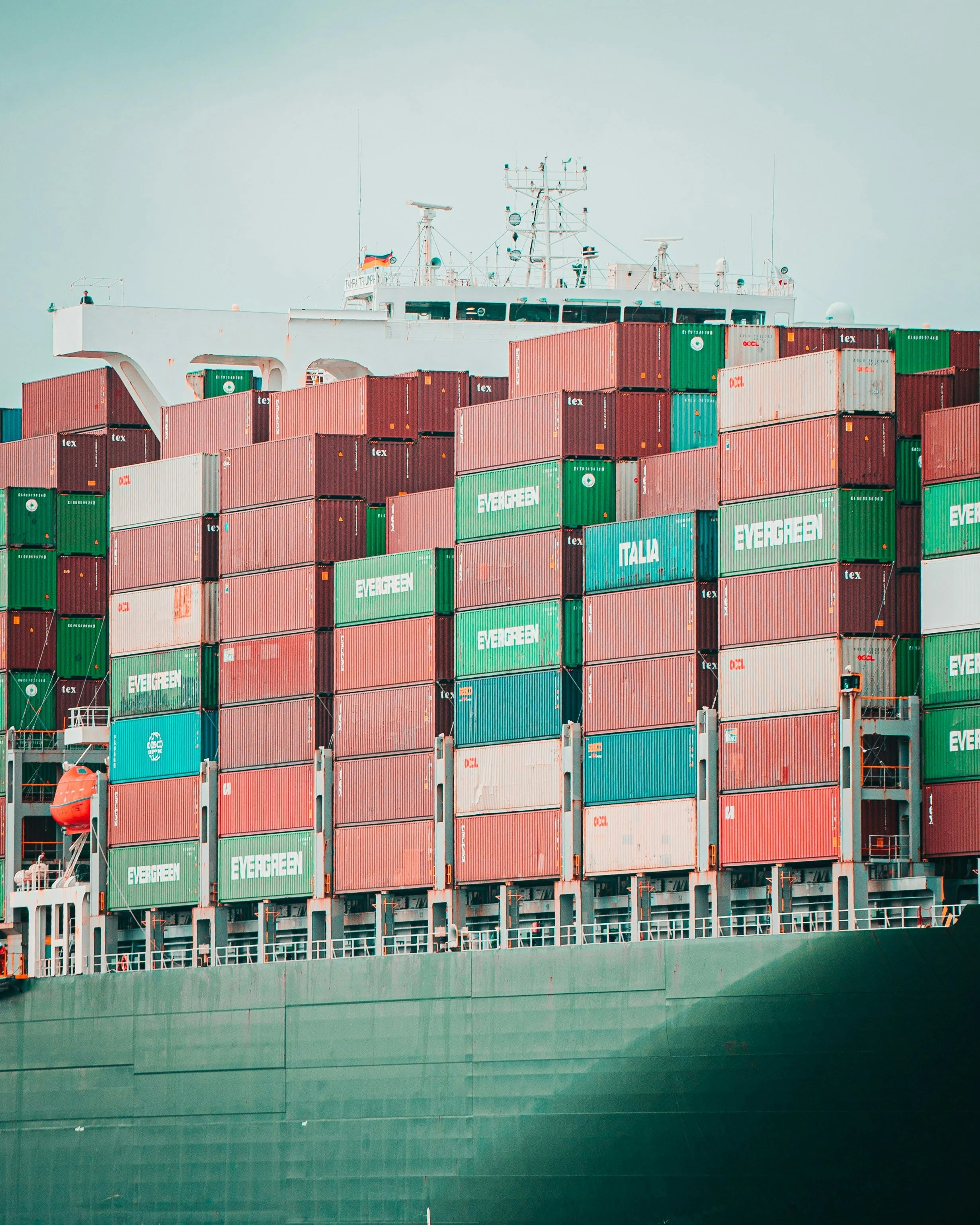 Close-up of stacked green, red and blue shipping containers on a cargo ship