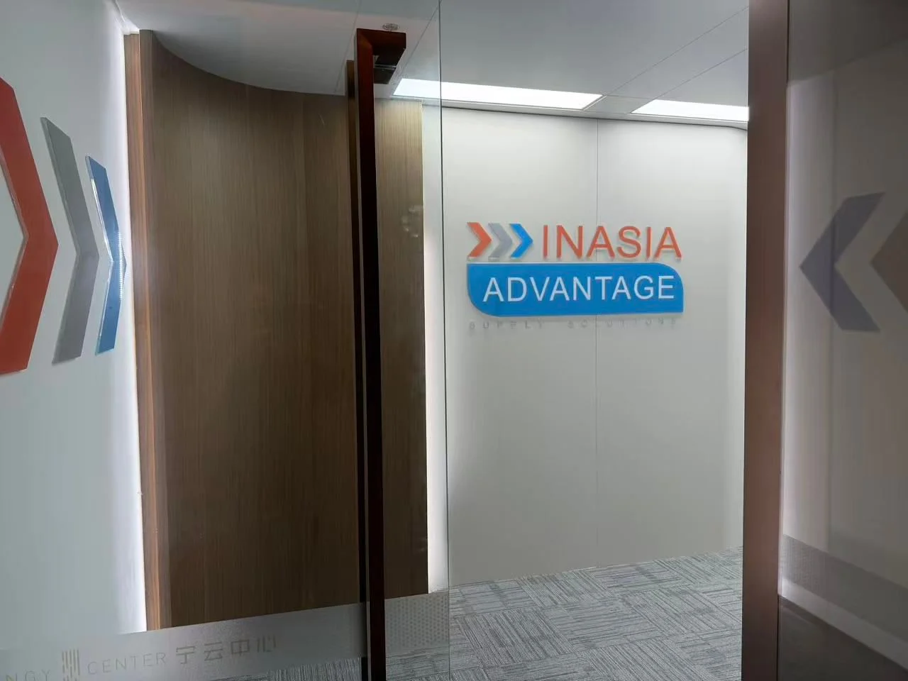 Glass office entrance with the InAsia Advantage logo on the wall behind it
