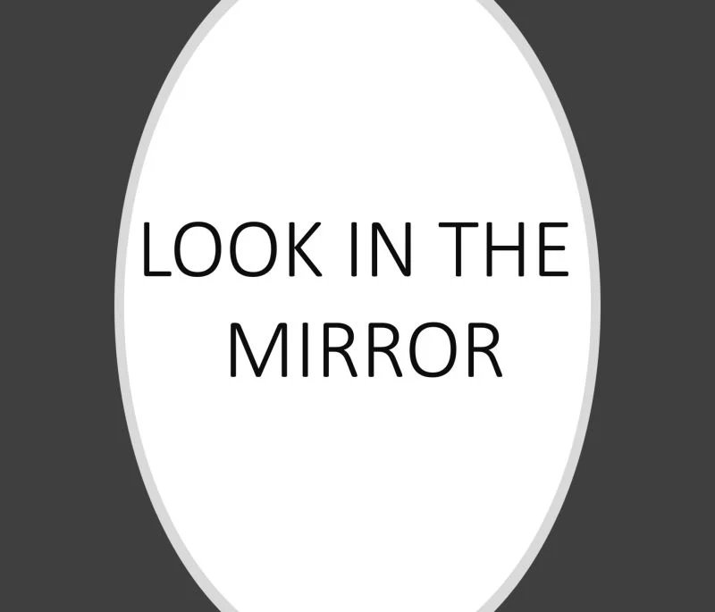 White oval on a dark grey background containing the words Look in the mirror